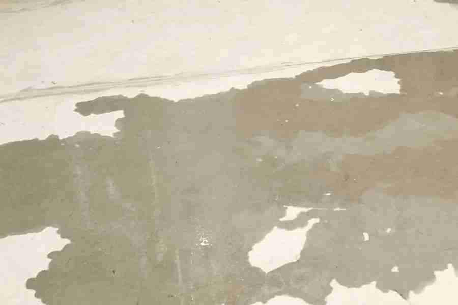 Water spreading across a bare concrete slab floor beneath lifted flooring in a Peoria AZ home